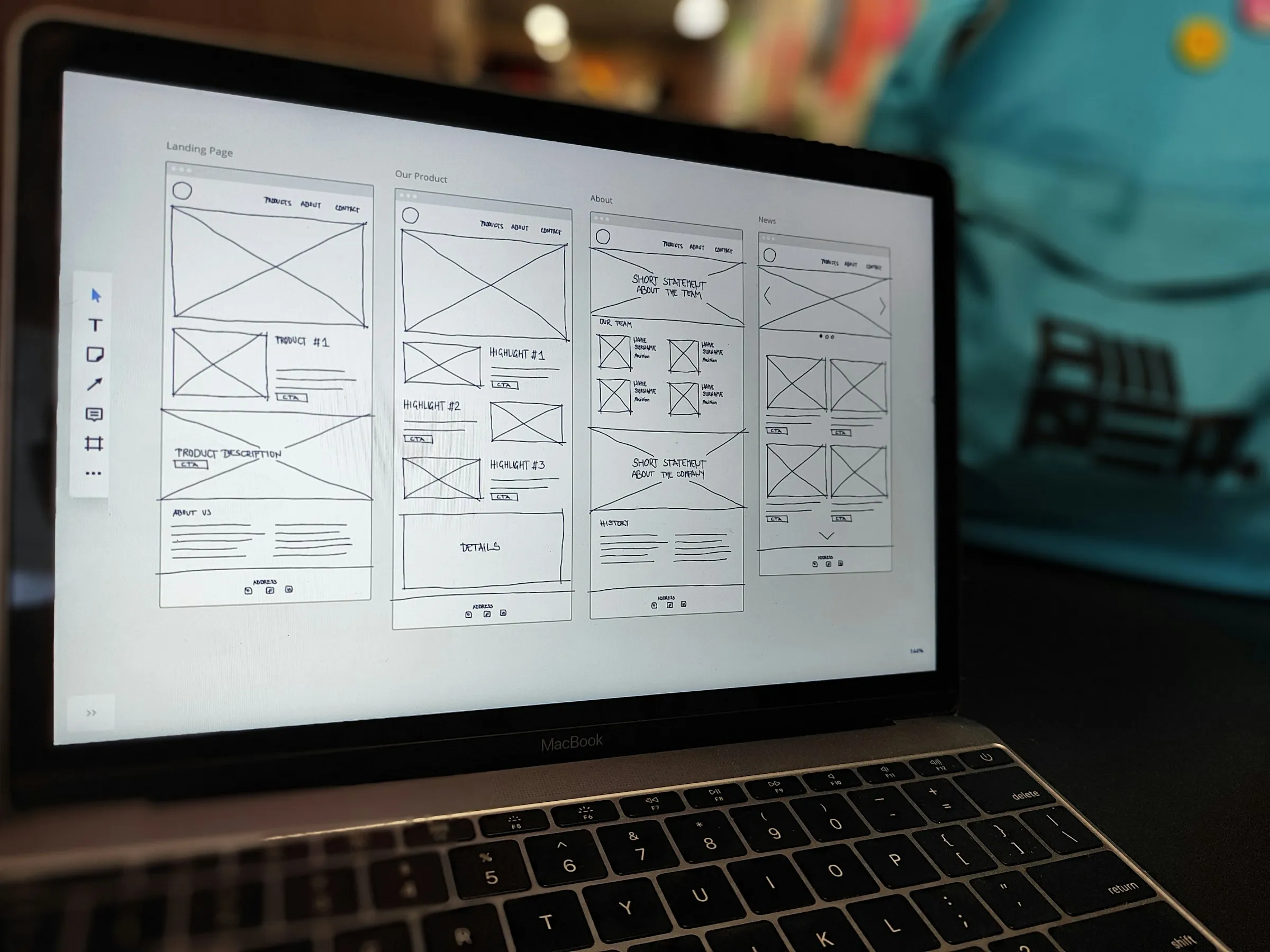 Laptop screen showing grayscale wireframes for several website pages